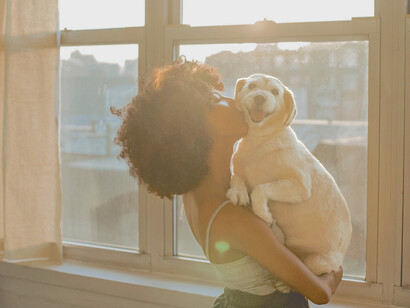 Mulher abraça e beija seu cachorrinho