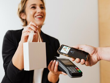 O smartphone se aproxima do terminal para concluir uma compra sem o uso de dinheiro físico. A facilidade do gesto esconde a complexa rede digital que registra, processa e conecta cada transação