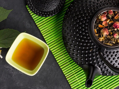 Herbal tea and its dried ingredients arranged on a green placemat