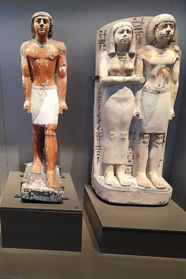 Polychrome limestone statues of an Old Kingdom noble and a standing couple statue on display at the Egyptian Museum in Cairo, Egypt