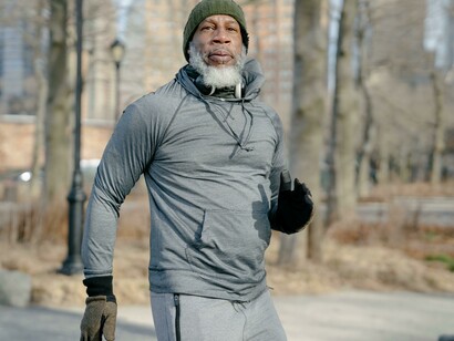 A senior Black man exercising outdoors in a park during the fall, embracing a healthy lifestyle