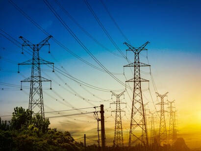 Electrical grid infrastructure extending across the horizon, representing the race to meet the energy requirements of AI-powered data centres