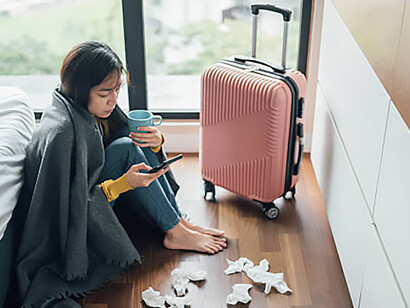 A woman sits on the floor beside her suitcase, crying after leaving an emotionally abusive relationship