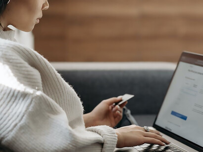 A woman diligently enters her card information into her laptop