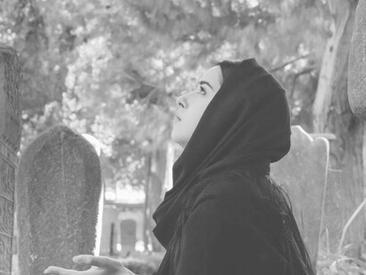 A woman looking for answers with head raised in the cemetery 