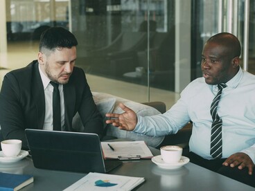 Two colleagues reviewing business matters together, reflecting strategic support and stronger employee relationships