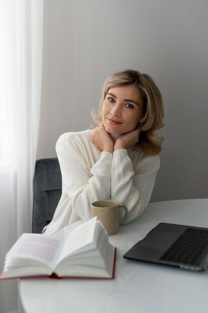 A woman sits peacefully at home, journaling mindfully in a tranquil workspace—a quiet space for reflection on her personal growth journey