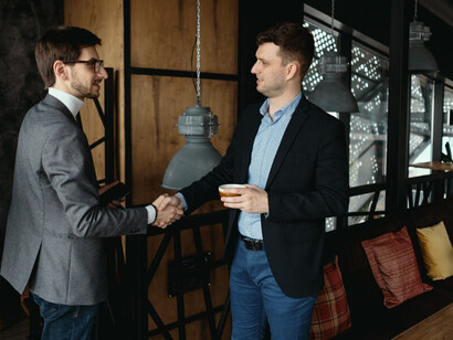Two young businessmen greeting each other, shaking hand