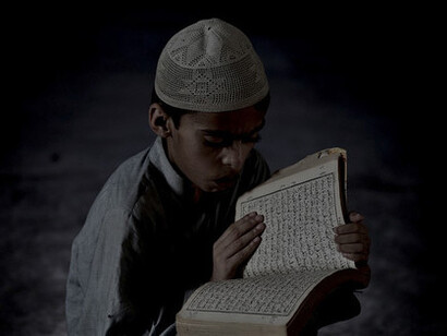 Un niño leyendo el Corán