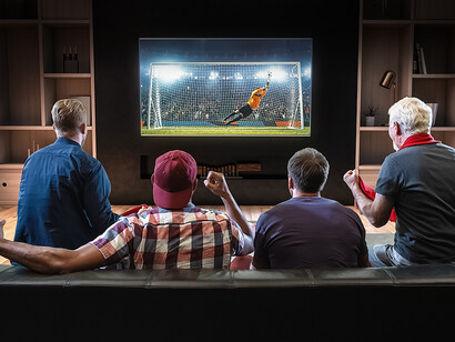 Grupo de amigos mirando el fútbol en la televisión