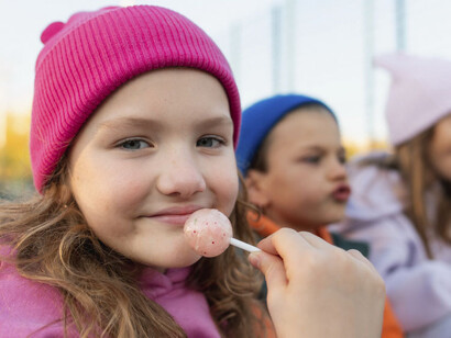 Una niña contenta por haber faltado a la escuela, pasa un lindo día con amigos mientras comen golosinas