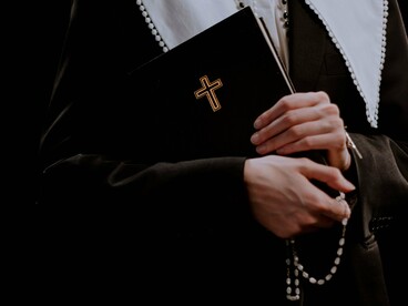 A believer holding the Bible and a rosary, reflecting an unwavering desire to remain faithful to God