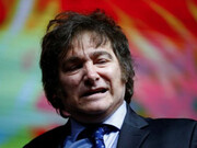 Close up of President Javier Milei on stage, with his iconic ''wig'' of messy hair