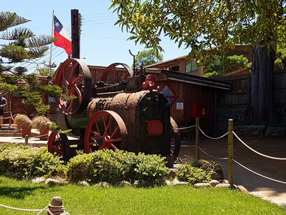 Isla Negra con locomobil, ancestro de los actuales tractores agrícolas *multiuso* y bandera de Chile
