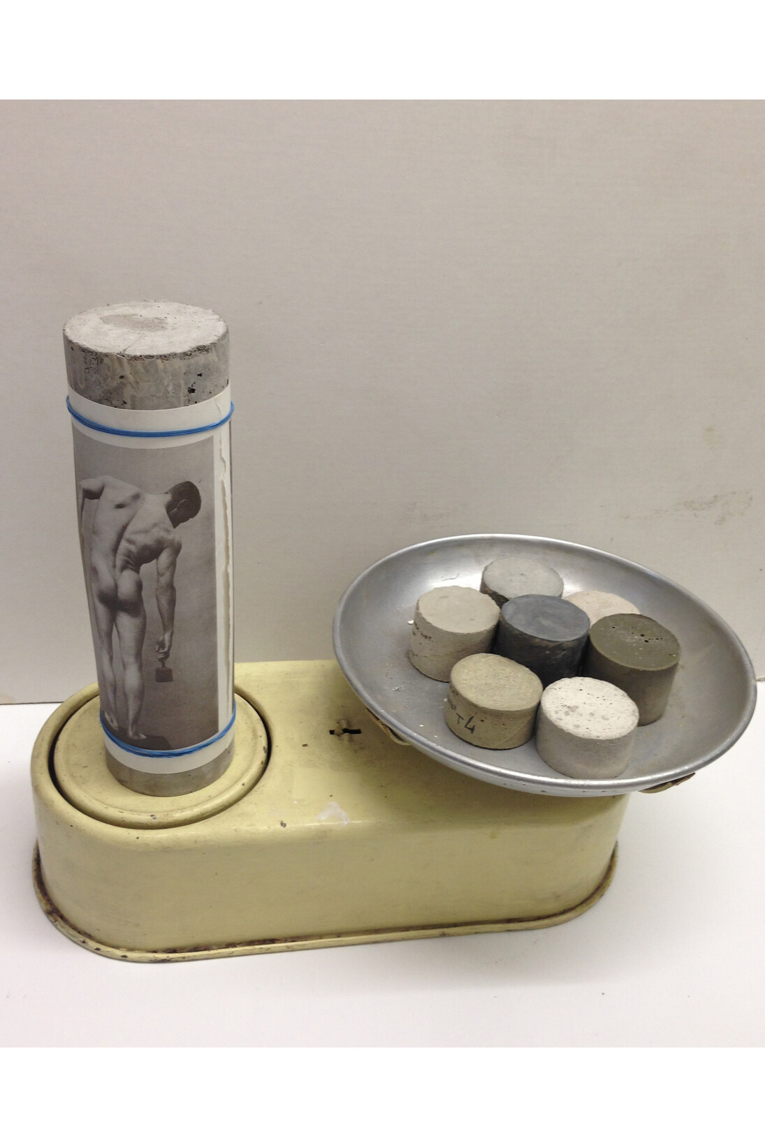 Mariana Mauricio, Balança, 2014, Concreto, papel, elástico, balança de metal, 34.5 x 40.5 x 23.5 cm