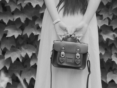 A woman wearing a watch on her wrist and holding a bag to indicate she's always on the go