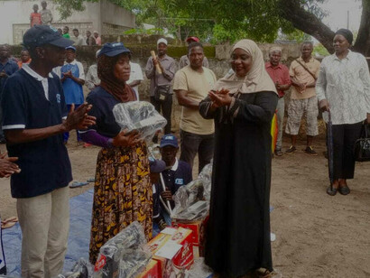Uma mulher busca seus produtos do programa de subsídio social básico, Nampula, Moçambique