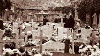 Grupo de pessoas presta homenagem a um ente querido em um cemitério. O enfrentamento da finitude envolve não apenas quem está partindo, mas também aqueles que permanecem e aprendem a conviver com a perda. A morte faz parte da experiência humana, e compreender esse processo pode ajudar a tornar o luto menos solitário
