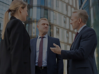 The lobbying team gathers in the city, engaging in strategic discussions against a backdrop of towering office buildings