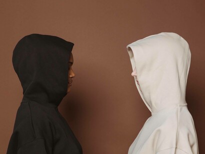 The two people wearing black and white hoodies face each other