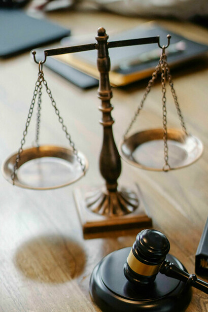 Balance de la justice et marteau du juge posés sur un bureau. Le droit international organise les relations entre États, leurs responsabilités, droits et devoirs
