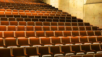 An atrium with empty seats; the author sees one filled with empty people 