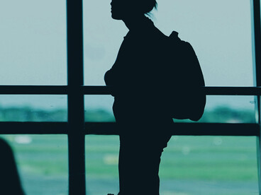 Surabaya, East Java, Indonesia, a silhouette of a woman with a backpack stands at an airport terminal