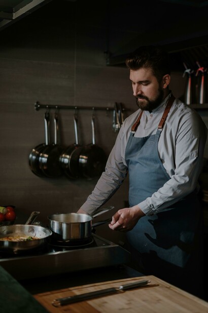 Ajudante de chef cozinha nas panelas