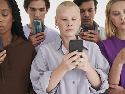 Jovens observam seus telefones apreensivamente. Não queremos viver para um objetivo, mas não podemos abdicar dele. Estamos submersos em vidas virtuais, contemplados por sofisticas utopias de vida distópicas, obcecados pelo progresso e o máximo de liberdade individual, o que consequentemente não nos permite parar e considerar o impacto psicológico desta loucura de procura incessante