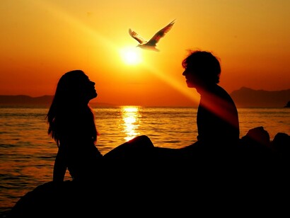 Un hombre y una mujer junto al mar al atardecer