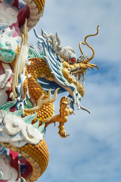 A colorful dragon statue rises against a clear sky in Thailand, inspired by Naga serpent mytholog
