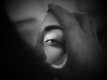 An eye reflected in a small, broken piece of mirror captures the intense introspection and self-awareness crucial for navigating relationship fears and understanding one's "shadow" archetype