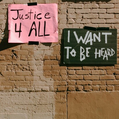 Carteles en la vía pública que dicen "Justicia para todos" y "Quiero ser escuchado"