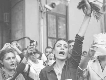 A woman showing a handful of hair in protest over the injustices occurring in Iran