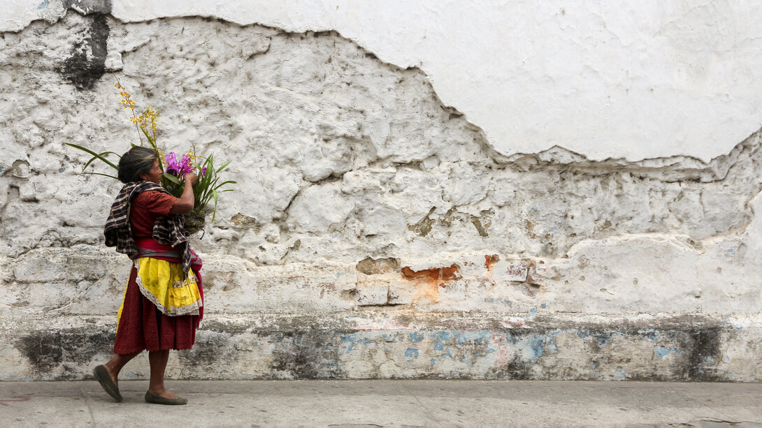 Mujer llevando un ramo de flores en la ciudad de Antigua, Guatemala