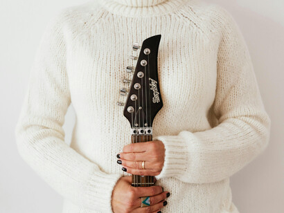 Una mujer sujeta una guitarra eléctrica. Uno de los elementos que más me atrapa de sus canciones son las partes declamadas