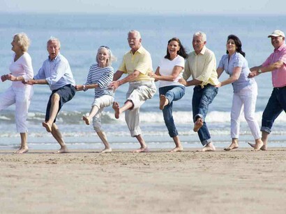 Grupo de baby boomers paseando por la playa