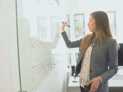 A woman concentrating and working on her idea validation board