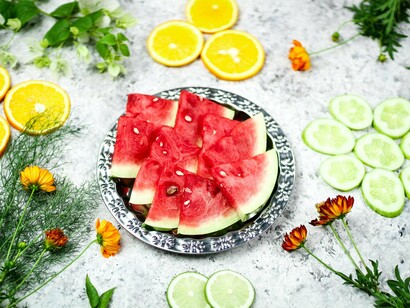 Watermelon, citrus fruits, and cucumber arranged on a serving platter, reflecting the importance of nutrient-rich foods for overall wellness
