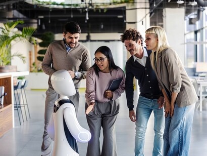 Business professionals collaborate with an AI-powered robot in a modern office