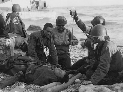 Hombres de la Cruz Roja administran una transfusión de sangre a un herido en la orilla de la playa de Omaha el 6 de junio de 1944