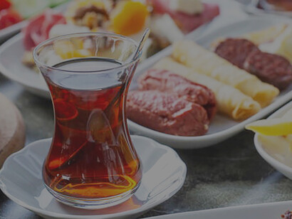 Behold a tableau of the iconic Turkish culinary experience: a table adorned with an array of dishes and cups of tea that together form a traditional and hearty Turkish-style breakfast spread