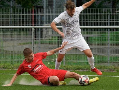 A defender recovers the ball from an attacker via a sliding tackle