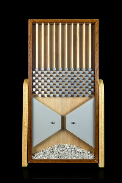 A Galton Board demonstrates how completely chaotic individual paths predictably form a normal distribution curve