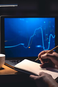 A man browses online stock investments at night, actively engaging in trading strategies for potential gains
