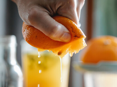 Autocuidado ao preparar um suco de laranja diretamente da fruta 