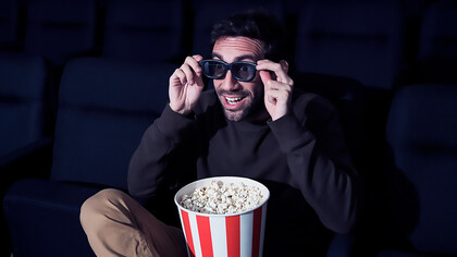 Man enjoying popcorn in movie theater