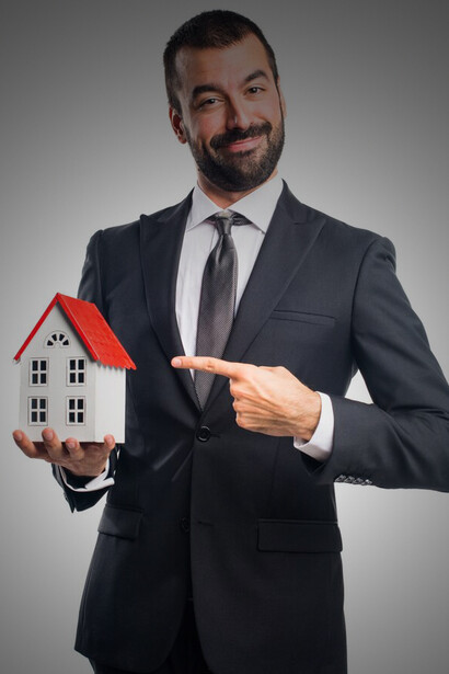 A realtor showcasing a miniature home, representing high-end real estate, exclusive opportunities, and the appeal of modern living