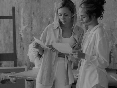 Two women are taking turns to compare photographs while adopting different angles and perspectives