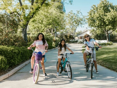 A family rides bicycles in a city park designed for sustainable and pedestrian-friendly living